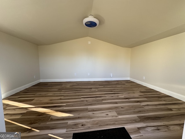 unfurnished room with dark hardwood / wood-style flooring and lofted ceiling