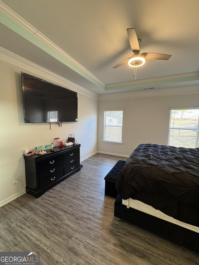 bedroom featuring ceiling fan, multiple windows, dark hardwood / wood-style flooring, and ornamental molding