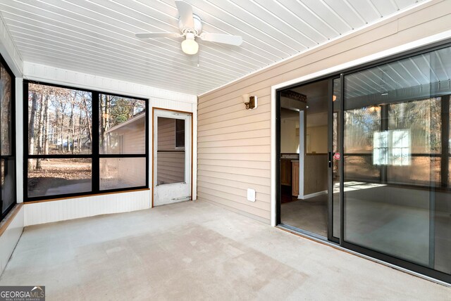 unfurnished sunroom featuring ceiling fan