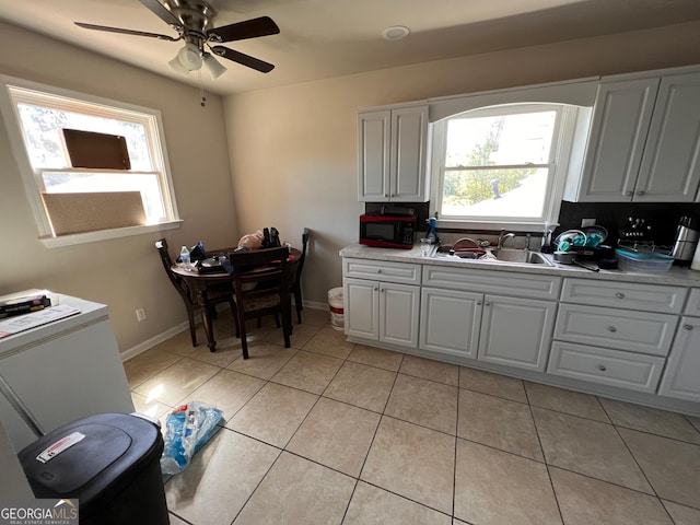 kitchen featuring sink, ceiling fan, white cabinetry, and light tile patterned flooring