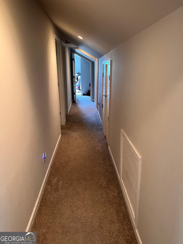 corridor with carpet and lofted ceiling