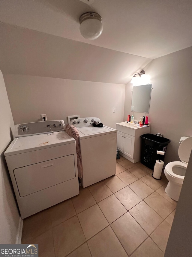 bathroom with tile patterned floors, vanity, washing machine and clothes dryer, toilet, and vaulted ceiling