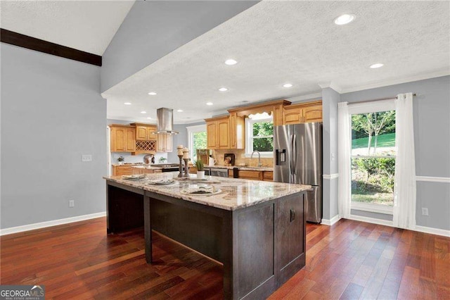 kitchen with sink, stainless steel fridge with ice dispenser, a center island, and lofted ceiling