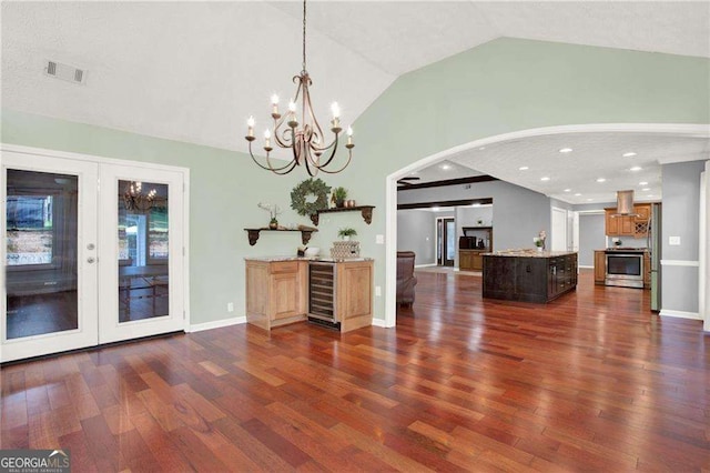 interior space featuring lofted ceiling, a kitchen island, stainless steel range, island range hood, and wine cooler