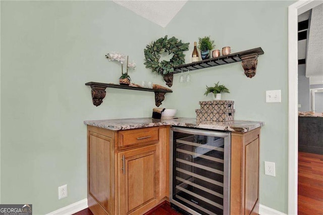 bar featuring dark hardwood / wood-style flooring and beverage cooler