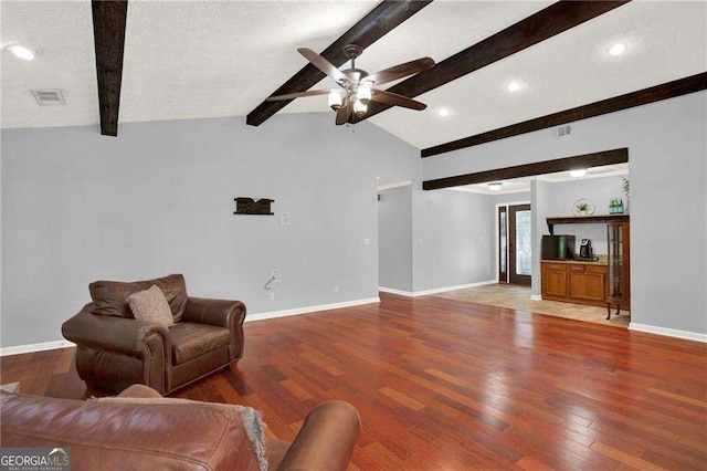 living room featuring lofted ceiling with beams, a textured ceiling, hardwood / wood-style floors, and ceiling fan