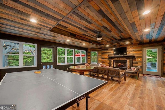 recreation room with a fireplace, wood walls, a wealth of natural light, and wooden ceiling