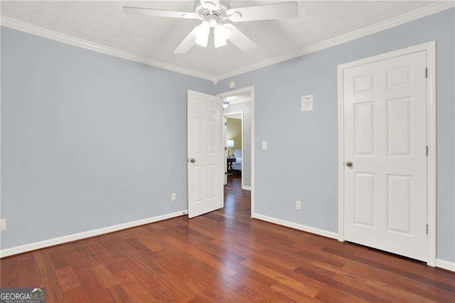 unfurnished bedroom featuring ceiling fan, dark wood-type flooring, and crown molding