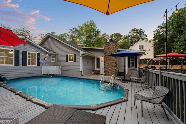 pool at dusk with a wooden deck