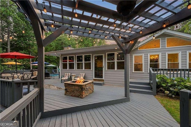 wooden deck with a fire pit and a pergola