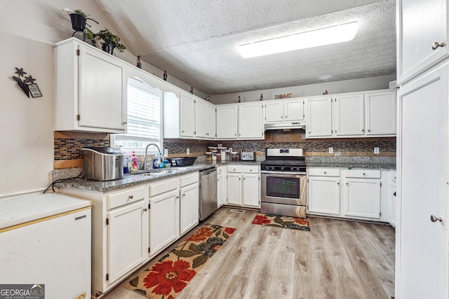 kitchen with white cabinets, a textured ceiling, appliances with stainless steel finishes, and sink