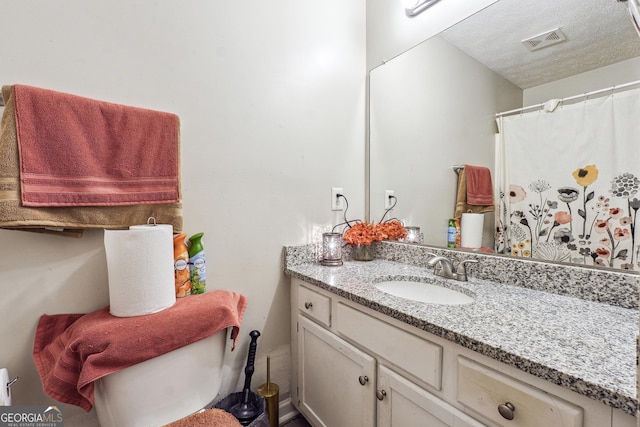 bathroom with a textured ceiling and vanity