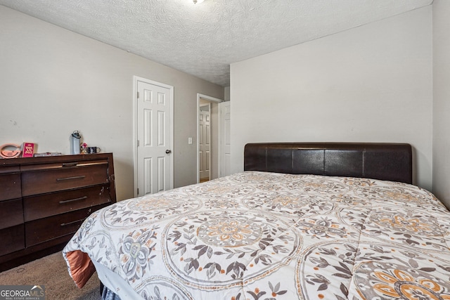 bedroom featuring a textured ceiling and carpet flooring