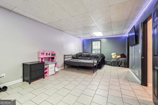 tiled bedroom featuring a paneled ceiling