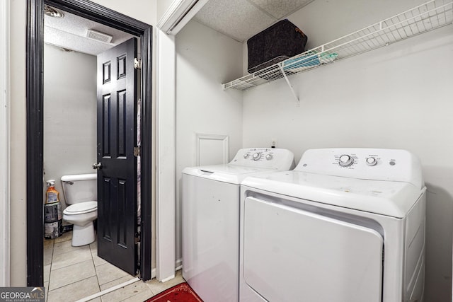 laundry room with separate washer and dryer and light tile patterned floors