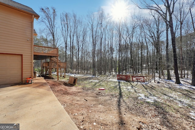 view of yard with a garage and a wooden deck