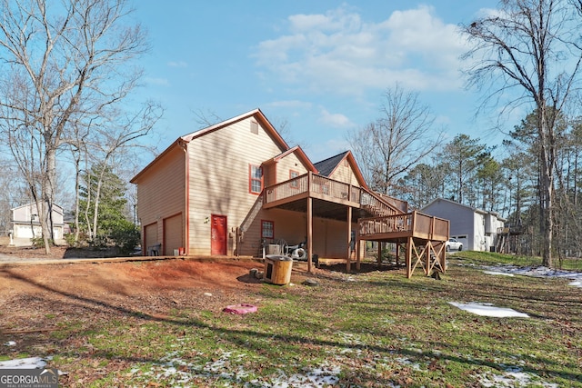 back of property featuring a garage and a wooden deck