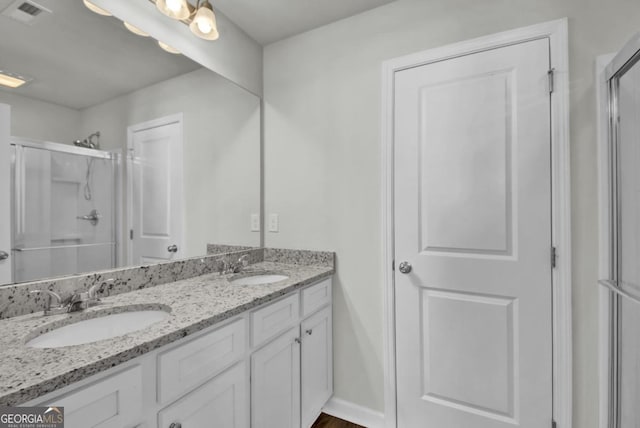 bathroom with hardwood / wood-style flooring, a shower with shower door, and vanity