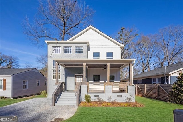 view of front of house featuring ceiling fan, a porch, and a front lawn