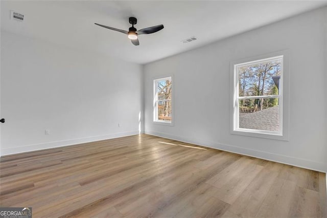 unfurnished room with light wood-type flooring, ceiling fan, and plenty of natural light