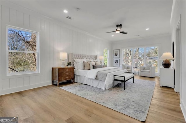 bedroom with multiple windows, light hardwood / wood-style flooring, ceiling fan, and ornamental molding