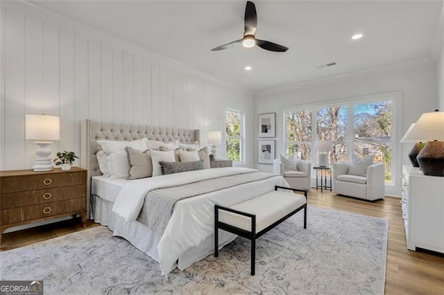 bedroom with crown molding, hardwood / wood-style flooring, multiple windows, and ceiling fan