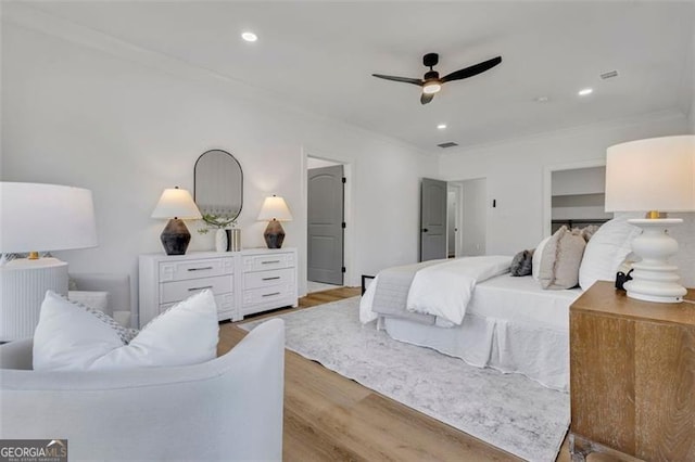 bedroom with ceiling fan, light hardwood / wood-style floors, and ornamental molding