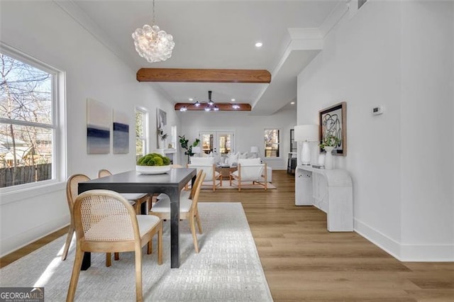 dining room featuring a notable chandelier, beamed ceiling, and light hardwood / wood-style floors