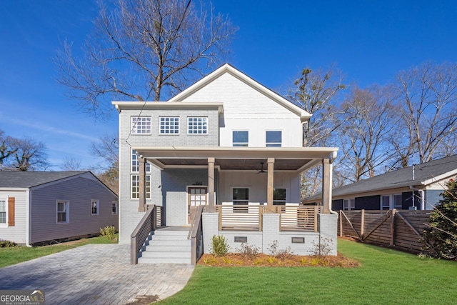 view of front facade with ceiling fan, a front yard, and a porch