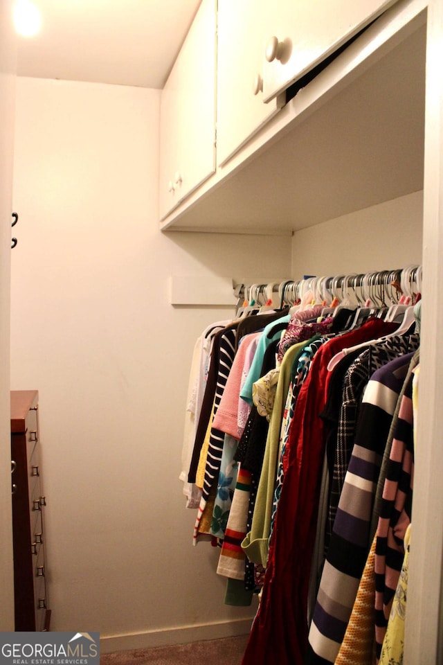 walk in closet with carpet