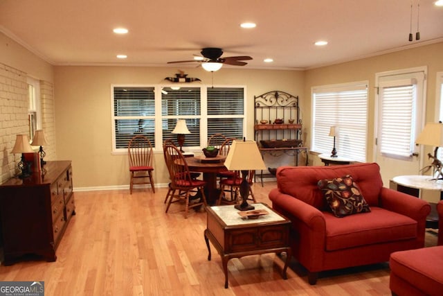 living room with ornamental molding, ceiling fan, and light hardwood / wood-style flooring