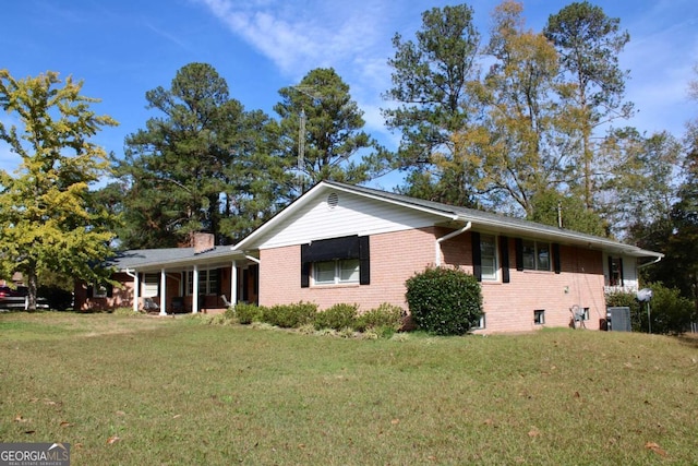 view of front of property with central AC and a front lawn