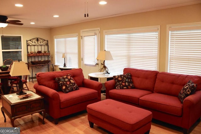 living room with ceiling fan, ornamental molding, and light hardwood / wood-style floors