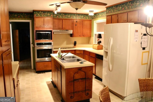 kitchen with appliances with stainless steel finishes, ceiling fan, a kitchen island with sink, and sink