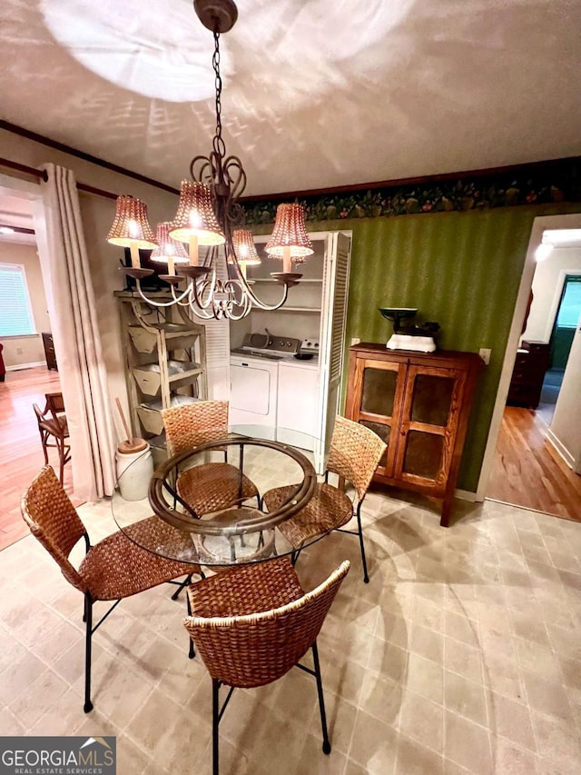 dining area featuring a chandelier and washer and clothes dryer