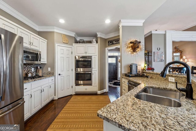 kitchen featuring sink, stainless steel appliances, white cabinets, and light stone countertops