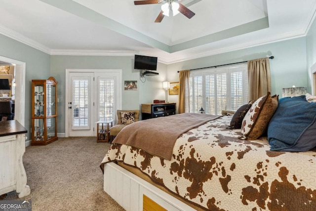 carpeted bedroom featuring ceiling fan, access to outside, crown molding, and a tray ceiling