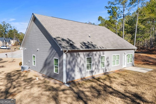 rear view of house featuring a patio area, central AC unit, and a lawn