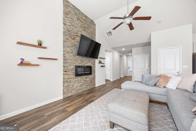 living room with ceiling fan, dark wood-type flooring, high vaulted ceiling, and a fireplace