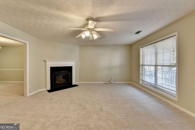 unfurnished living room featuring light carpet, a textured ceiling, and ceiling fan