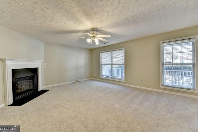 unfurnished living room featuring a textured ceiling, ceiling fan, and light carpet