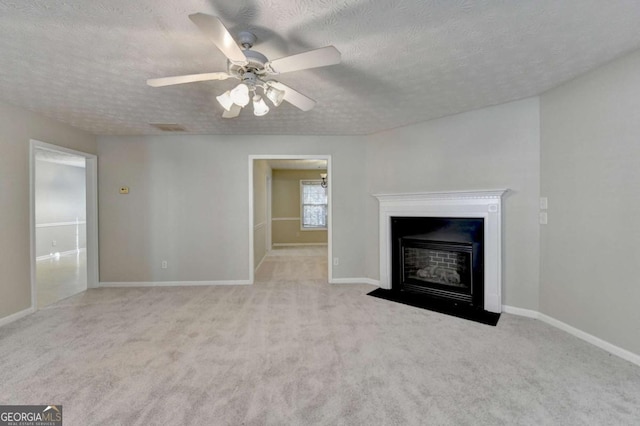 unfurnished living room featuring ceiling fan, light colored carpet, and a textured ceiling