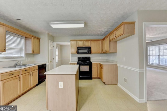 kitchen with black appliances, sink, a textured ceiling, and a kitchen island