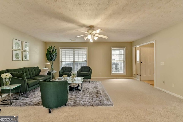 carpeted living room with a textured ceiling and ceiling fan