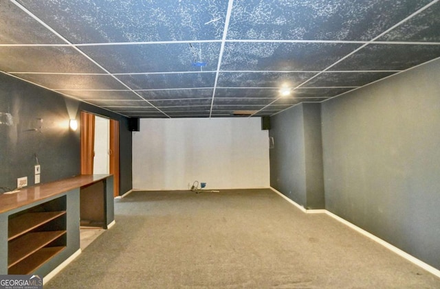 basement featuring carpet floors and a paneled ceiling