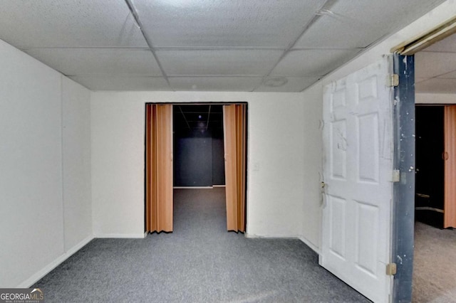 unfurnished room featuring a drop ceiling and carpet