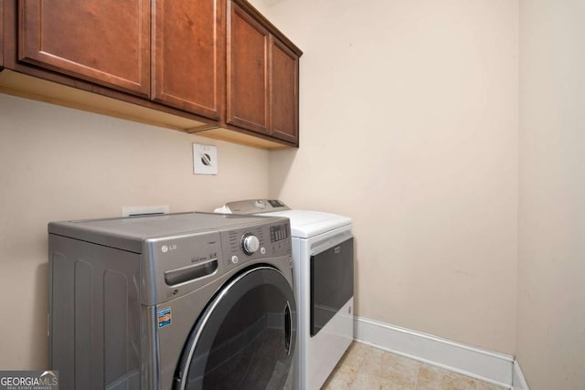 washroom featuring separate washer and dryer and cabinets