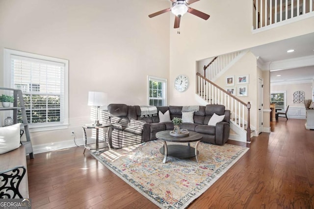 living room featuring a high ceiling, ceiling fan, and dark wood-type flooring