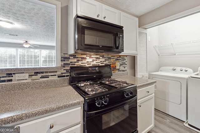 kitchen featuring black appliances, ceiling fan, white cabinets, light hardwood / wood-style flooring, and washing machine and clothes dryer