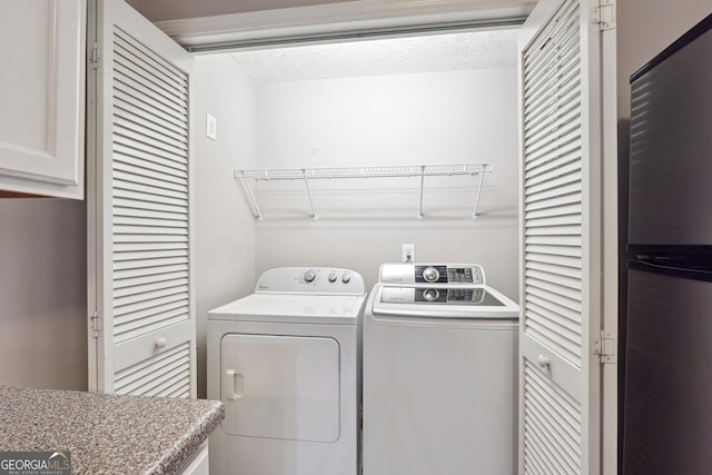 washroom with a textured ceiling and independent washer and dryer